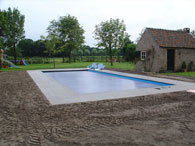 De terras tegels zijn gelegd en de grond rondom geëgaliseerd.